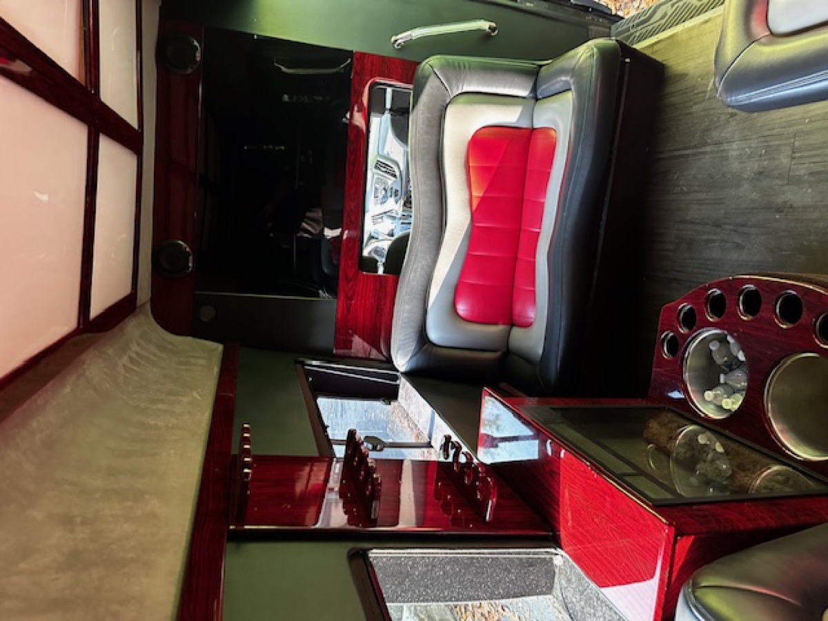 Sprinter interior — full cabin view with wet bar, leather seating, and mirrored ceiling