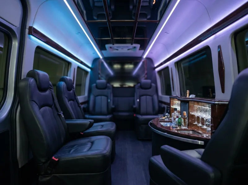 Sprinter interior — full cabin view with wet bar, leather seating, and mirrored ceiling